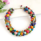 A multicolor beaded collar necklace rests against a white background.