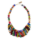 A multicolored beaded & fringe necklace is seen against a white background.