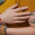 A close up of a woman's hand and the two gold rings on her fingers.