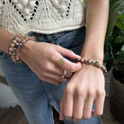 A close up of a woman's wrist as she adjusts her beaded bracelet.