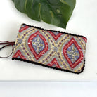 A yellow & red eyeglass case against a white background, with a pair of red eyeglasses sticking out of the pouch.