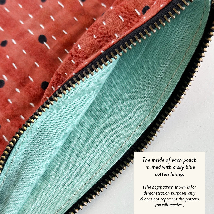 A close up of the light blue inside lining of a pink Kantha pouch.