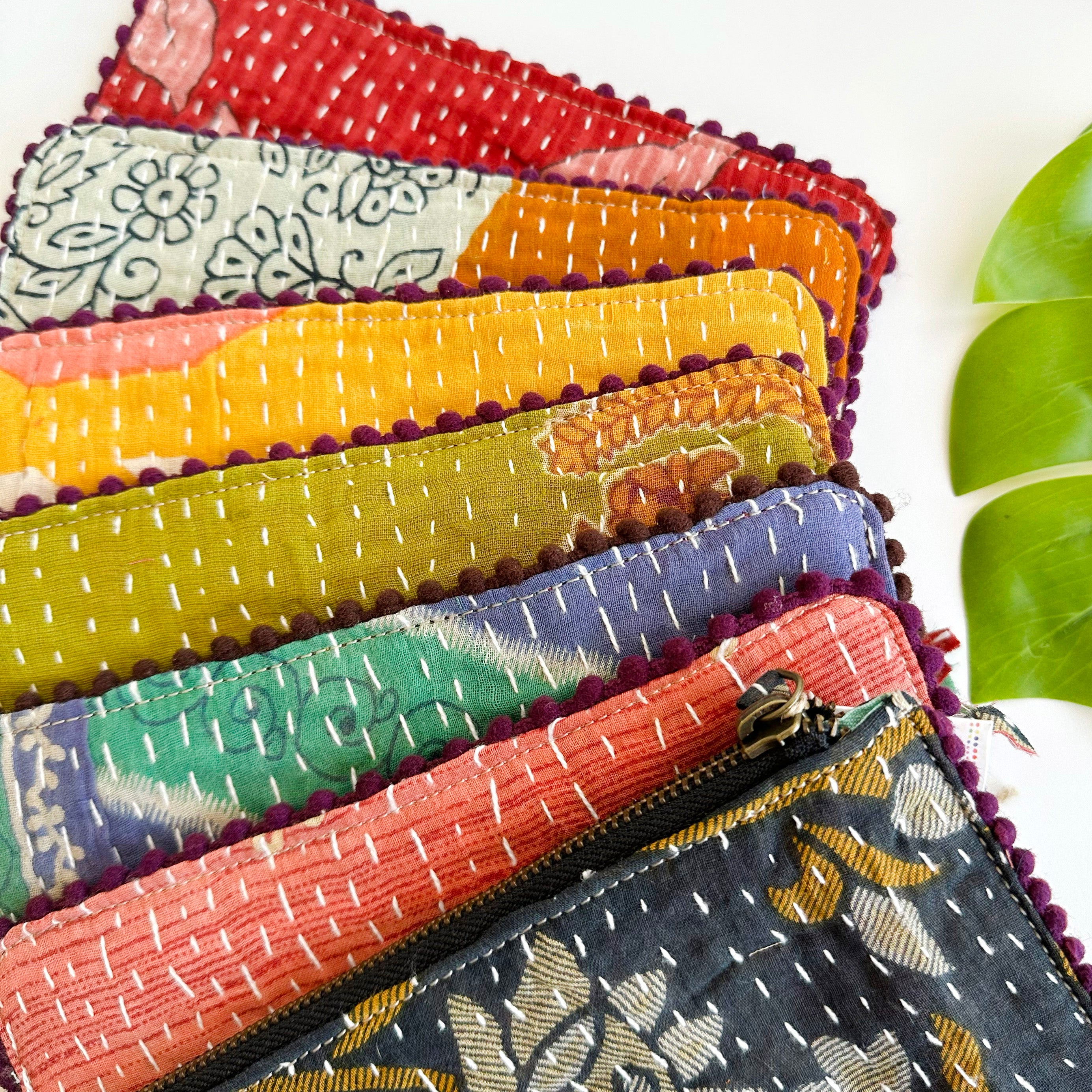 Seven quilted pouches are layered to form a rainbow of color.