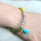 A close up of a woman's wrist and the pastel beaded bracelet she wears.