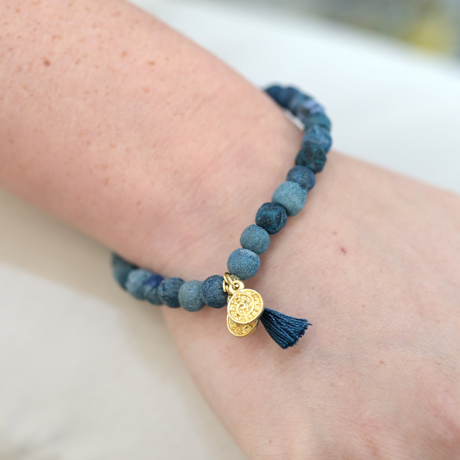 A close up of a woman's wrist and the blue beaded bracelet she wears.