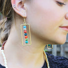 A close up of a woman's ear and her earrings.