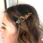 A close up of a woman's hair and the beaded multicolor hair accessory she is wearing.