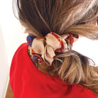 A close up of a tan scrunchie in a woman's hair.