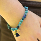 A close up of a woman's wrist and the blue beaded bracelet she wears.