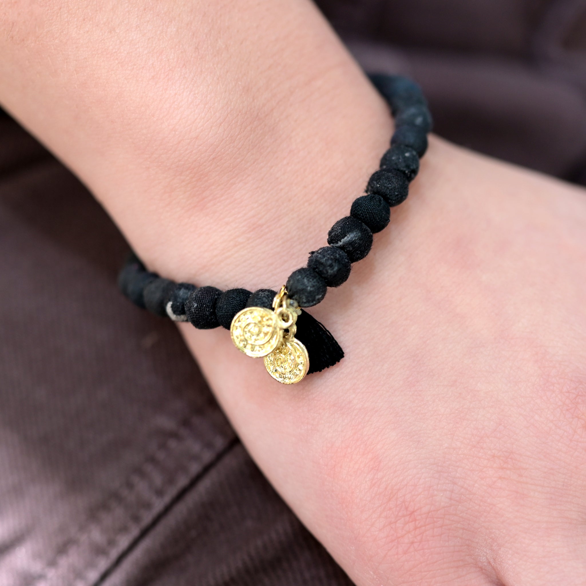 A close up of a woman's wrist and the black beaded bracelet she wears.